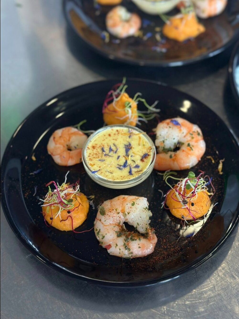 Crevettes accompagnées d'une mousse aux fleurs comestibles