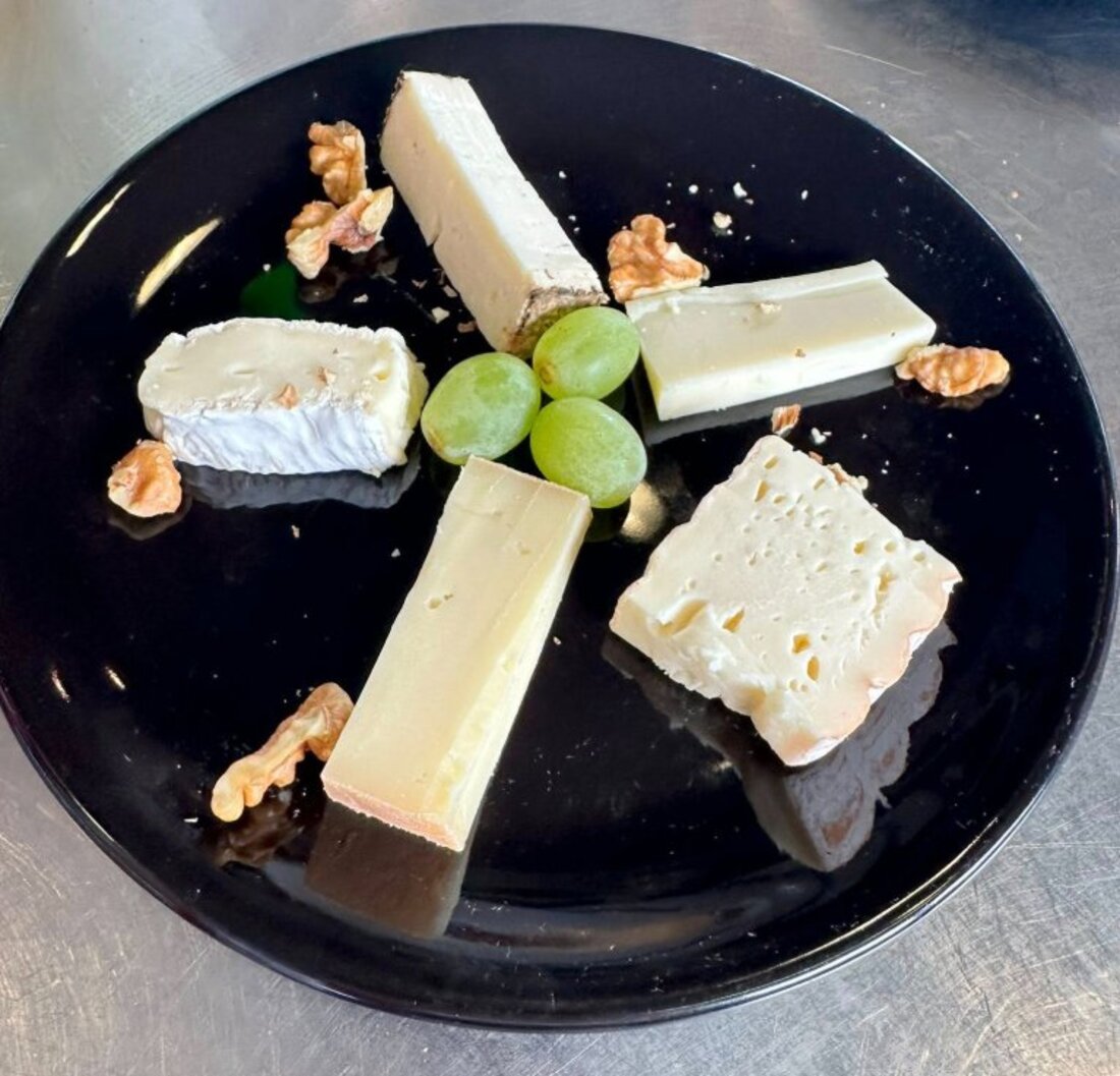 Plateau de fromages locaux servi avec raisin et noix